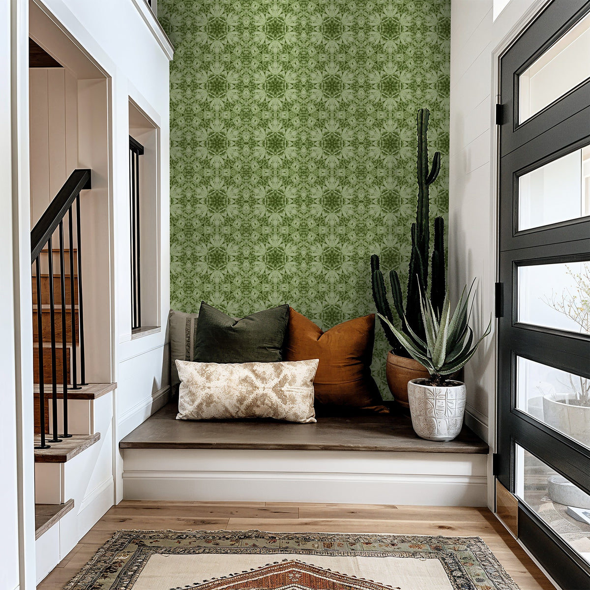 Green botanical wallpaper in modern entryway with plants and cushions.